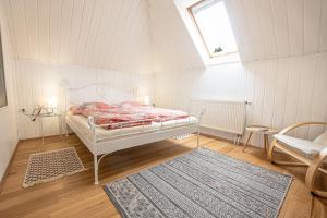 1 dormitorio con cama, ventana y alfombra en Lichtenštejnské domky en Lednice