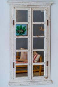 a white window with a reflection of a room at Calma Hotel in Ciutadella