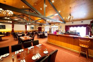 a restaurant with tables and chairs and a bar at Sanctuary House Resort Motel in Healesville