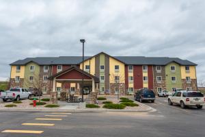 un grand bâtiment avec des voitures garées dans un parking dans l'établissement My Place Hotel-Cheyenne, WY, à Cheyenne