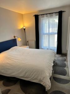 1 dormitorio con cama blanca y ventana en Appartement Lumineux Accor Arena Paris 13, en París