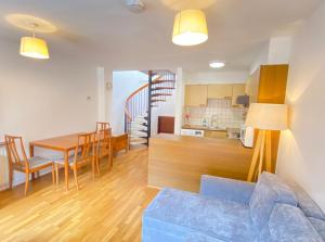 uma sala de estar e cozinha com um sofá azul e uma mesa em Cosy duplex in Central London em Londres