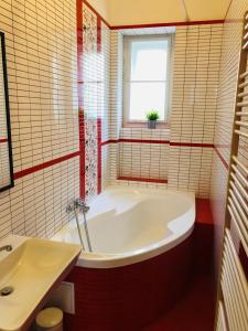baño con bañera blanca y lavamanos en Adam&Eva Rooms, en Praga