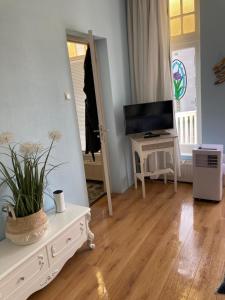 uma sala de estar com uma televisão e uma mesa branca em Hendrika Apartments em Zandvoort