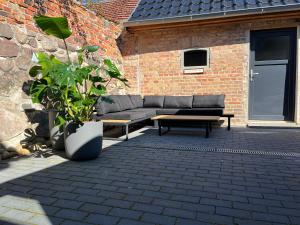 a couch sitting on a patio next to a brick building at Kleinstadtidyll Plau am See in Plau am See