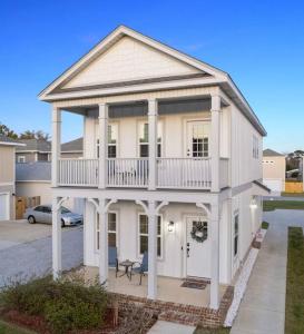 ein großes weißes Haus mit Balkon oben in der Unterkunft Cheerful 3BR close to downtown + double balcony in Pensacola