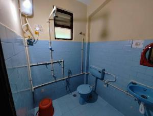 uma casa de banho azul com um WC e um lavatório em Sea View Resorts em Bogmalo