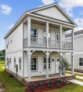 ein großes weißes Haus mit einem großen Balkon in der Unterkunft Cheerful 3BR close to downtown + double balcony in Pensacola