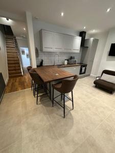 uma cozinha com uma mesa de madeira e cadeiras em Stunning 2 bedroom let’s BBQ. em Brighton & Hove