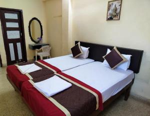 - une chambre avec 2 lits avec des draps blancs et bruns dans l'établissement Sea View Resorts, à Bogmalo Beach