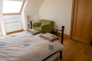a bedroom with a bed and a green chair at Osher Apartment in Enniscorthy