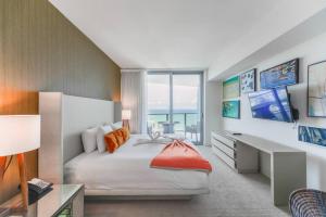 1 dormitorio con cama, escritorio y ventana en Beachfront Paradise - Luxurious Condo at Hollywood, en Hollywood