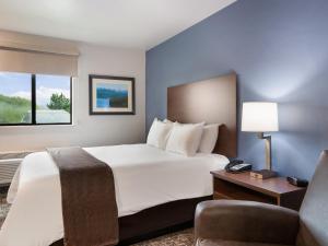 a hotel room with a large bed and a chair at My Place Hotel-Cheyenne, WY in Cheyenne