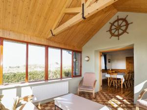 a living room with windows and a wooden ceiling at Mullaneys in Enniscrone