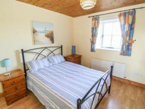 a bedroom with a bed and a window at Mullaneys in Enniscrone
