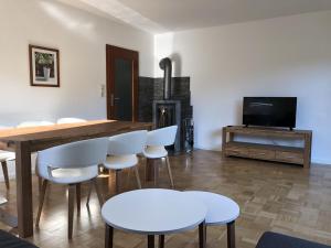 een woonkamer met een houten tafel en witte stoelen bij Ferienhaus Bibernest in Münsingen