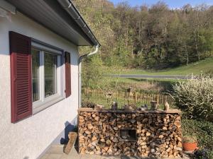 een raam van een huis met een stapel brandhout bij Ferienhaus Bibernest in Münsingen