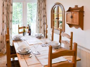 a dining room table with plates and wine glasses at Walnut Cottage in Long Melford