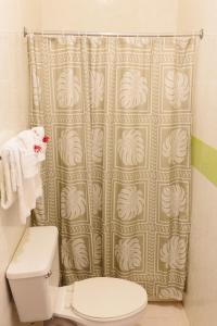 a bathroom with a shower curtain and a toilet at Galina Breeze in Port Maria