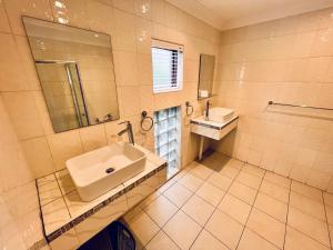エデンベールにある6 on Columbus Guesthouseの洗面台と鏡のあるバスルーム