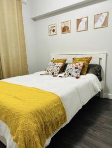 Una cama con manta amarilla y almohadas. en Fantastique 3 chambres modernes au cœur de la ville en Montreal