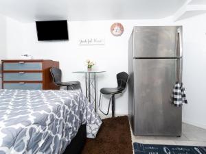 ein Schlafzimmer mit einem Kühlschrank, einem Tisch und 2 Stühlen in der Unterkunft Exquisite in Brooklyn