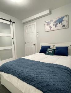 1 dormitorio con 1 cama grande con manta azul en Fantastique 3 chambres modernes au cœur de la ville en Montreal