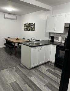 una cocina con armarios blancos y una mesa con fregadero en Fantastique 3 chambres modernes au cœur de la ville en Montreal