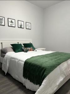 1 dormitorio con 1 cama grande con manta verde en Fantastique 3 chambres modernes au cœur de la ville en Montreal