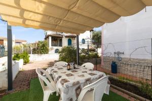 einen Tisch und Stühle unter einem großen Schirm in der Unterkunft Casa a due passi dal mare in Àrbatax