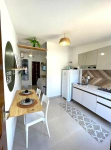 a kitchen and living room with a table and a refrigerator at AP1 Atrás da passarela do caranguejo - Orla de Atalaia in Aracaju