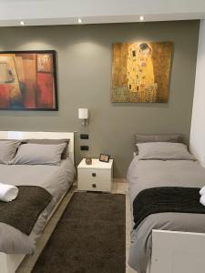 ローマにあるVatican Point Break - Alloggio Turistico - Roma Vaticanoのベッドルーム1室(ベッド2台付)が備わります。壁には絵画が飾られています。