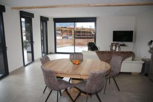 salon z drewnianym stołem i krzesłami w obiekcie Charmant chalet, spacieux, proche du lac, vue sur la montagne w mieście Gérardmer
