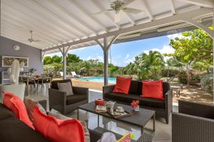 an outdoor living room with couches and a table at Villas Palm in Le Vauclin