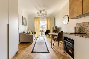 a kitchen and living room with a table and chairs at Golden Apartments Warsaw - Mennica Residence in Warsaw