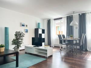 a living room with a tv and a table with chairs at Ferienwohnungen Lebenswert Ferienwohnung Lebenswert I in Meersburg