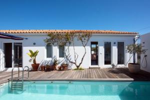 a villa with a swimming pool in front of a house at Sanderling beach & dune house in Carrapateira