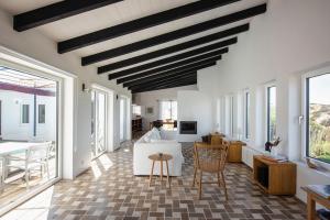 a living room with a vaulted ceiling at Sanderling beach & dune house in Carrapateira