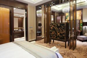 a bedroom with a bed and a dressing room at Crowne Plaza Xiangyang, an IHG Hotel in Xiangyang