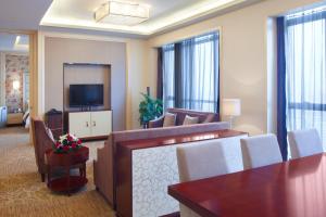 a living room with a couch and a television at Crowne Plaza Xiangyang, an IHG Hotel in Xiangyang