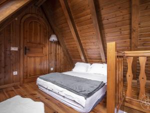 a bedroom with a bed in a wooden cabin at CASA REINA de Alma de Nieve in Tredós