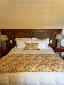 a large bed with two pillows and two lamps at Les Bergeries d'Arone in Piana