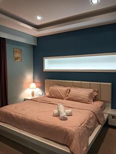 ein Schlafzimmer mit einem großen Bett mit blauer Wand in der Unterkunft GS Suite & Homestay in Ipoh
