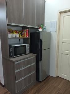 eine Küche mit einer Mikrowelle und einem Kühlschrank in der Unterkunft GS Suite & Homestay in Ipoh