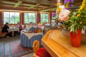 a restaurant with tables and people sitting at tables at Hotel Gut Kramerhof in Kirchdorf in Tirol