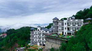 a hotel on top of a mountain with trees at Rosetum Kasauli in Kasauli