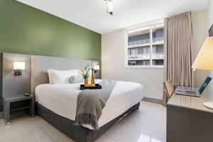 a bedroom with a bed and a desk with a laptop at Roami at Habitat Brickell in Miami