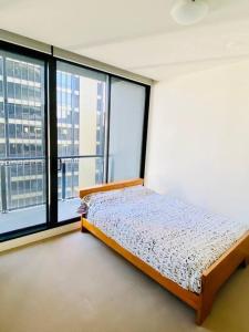 a bedroom with a bed and a large window at Two bedrooms apartment in the heart of Melb CBD in Melbourne