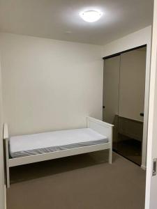 a white room with a bed and a mirror at Two bedrooms apartment in the heart of Melb CBD in Melbourne