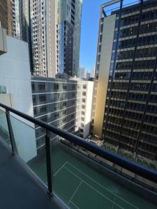 a balcony with a view of some tall buildings at Two bedrooms apartment in the heart of Melb CBD in Melbourne